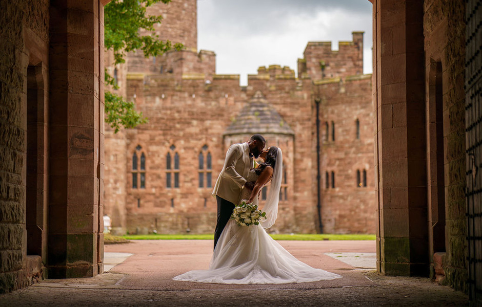 Couple in archway of peckforton castle